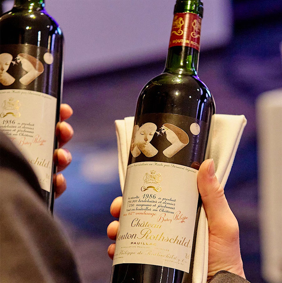     A server holds two bottles of Château Mouton-Rothschild 1986, with an artist label by Bernard Séjourné, at the New York Wine Experience 2022